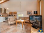 Ferienhaus Pauline - Wohnraum mit Kamin, offener Küche und Zugang zur Terrasse
