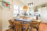Inselhaus Whg. 03 - Wohnzimmer mit offener Küche und Zugang zum Balkon