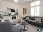 Ostseevilla Whg. 01 - Wohnzimmer mit offener Küche und Zugang zur Terrasse