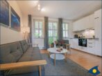 Villa Margot Whg. 26 - Wohnzimmer mit offener Küche und Zugang zum Balkon