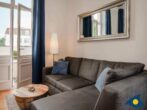 Villa Frisia Whg. 26 - Wohnbereich mit Couch und Blick auf Balkon