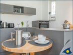 Villa Margot Whg. 14 - Wohnbereich mit offener moderner Küche und Zugang zum Balkon