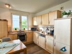 Haus Meeresrauschen Whg. 07 - Wohnzimmer mit Schlafcouch und offener Küche, Zugang zur Terrasse mit Meerblick