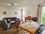 Haus Meeresrauschen Whg. 07 - Wohnzimmer mit Schlafcouch und offener Küche, Zugang zur Terrasse mit Meerblick