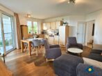 Haus Meeresrauschen Whg. 07 - Wohnzimmer mit Schlafcouch und offener Küche, Zugang zur Terrasse mit Meerblick