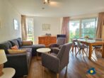 Haus Meeresrauschen Whg. 07 - Wohnzimmer mit Schlafcouch und offener Küche, Zugang zur Terrasse mit Meerblick