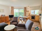 Haus Meeresrauschen Whg. 07 - Wohnzimmer mit Schlafcouch und offener Küche, Zugang zur Terrasse mit Meerblick