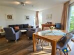 Haus Meeresrauschen Whg. 07 - Wohnzimmer mit Schlafcouch und offener Küche, Zugang zur Terrasse mit Meerblick