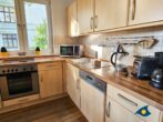 Haus Meeresrauschen Whg. 07 - Wohnzimmer mit Schlafcouch und offener Küche, Zugang zur Terrasse mit Meerblick