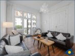 Appartement Agata - Wohnbereich mit Couch, TV und Blick zum Balkon