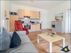 Ostseevilla Whg. 04 - Wohnzimmer mit offener Küche und Zugang zum Balkon