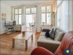 Ostseevilla Whg. 04 - Wohnzimmer mit offener Küche und Zugang zum Balkon