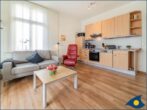 Ostseevilla Whg. 04 - Wohnzimmer mit offener Küche und Zugang zum Balkon