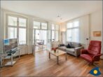 Ostseevilla Whg. 04 - Wohnzimmer mit offener Küche und Zugang zum Balkon
