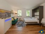 Ferienvilla Waldstraße Traumloft 16 - Wohnbereich mit Couch und Bett mit Schlaffunktion