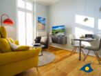 Residenz Bellevue Whg. 16 - Direkt am Strand - Wohnzimmer mit Küchenzeile, Essbereich und Zugang zum Balkon
