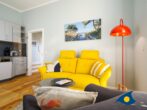 Residenz Bellevue Whg. 16 - Direkt am Strand - Wohnzimmer mit Küchenzeile, Essbereich und Zugang zum Balkon