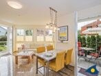 Dünen-Residenz C 05 - Wohnzimmer mit Essbereich und Zugang zum Balkon (links) und zur Hochterrasse (rechts)