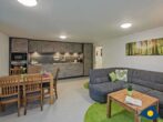 Ferienhaus Buntspecht - Wohnzimmer mit Essbereich und Küchenzeile