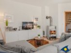 4-Sterne-Ferienhaus Anima mit Sauna, Kamin und Badeteich - Wohnbereich mit Couch, Kamin und TV