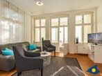 Ostseevilla Whg. 03 - Wohnzimmer mit Couch und TV und Zugang zur Loggia