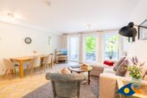Villa Strandperle, Whg. 18 - Wohnzimmer mit Schlafcouch und Zugang zum Balkon