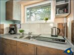 Haus Kiefernduene Balkonstudio links - Wohn-/Schlafbereich mit Sitzgelegenheit und Küchenzeile